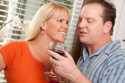 Happy Couple Enjoying a Glass of Wine the Kitchen.