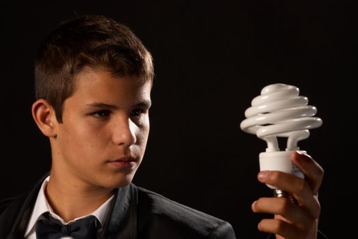 Environmental awareness, teen holding a energy saving bulb