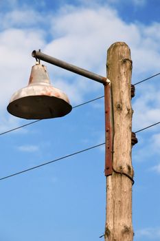 Old Lantern on a Wooden Pole Against a Blue Sky