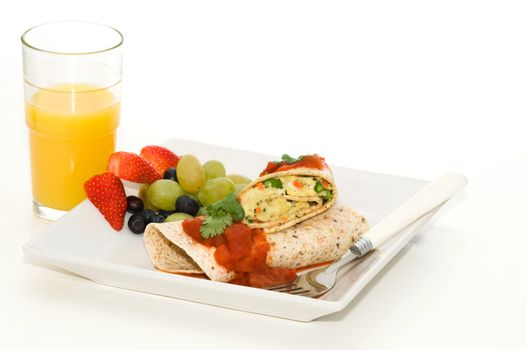 Delicious breakfast wrap with egg served with fresh fruit.