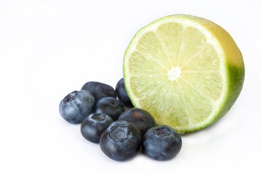 Lime and blueberries isolated on a white background. Used selective focus and a shallow depth of field.