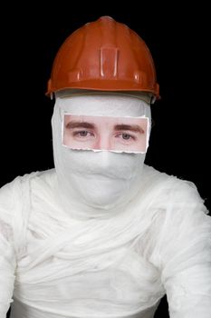 Bandaged man in helmet with false paper eyes on black