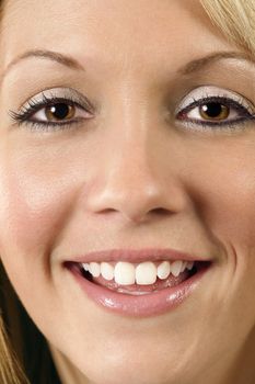 A closeup cropped image of a young woman smiling.
