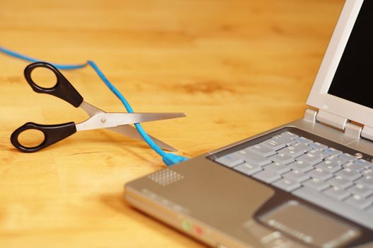 wireless network or wlan concept with laptopn scissors and cable