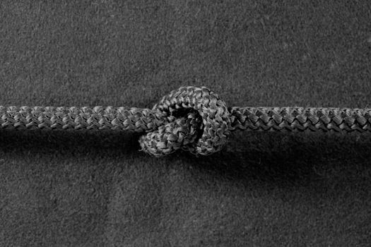Knot on cord on the textile black background