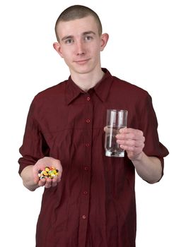 Young man with glass of water and tablets on hands