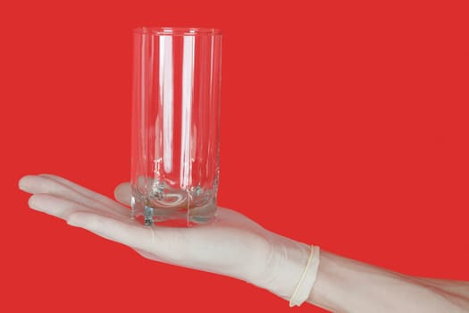 Glass on hand of water on hand on the red background