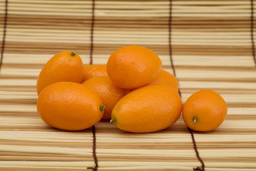 Still-life - the fresh kumquat against a mat