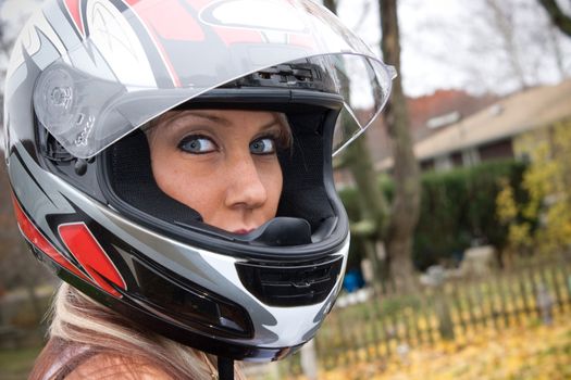 A pretty blonde girl wearing a motorcycle helmet.