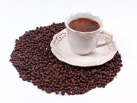 Cup of coffee and whole coffee beans isolated on white background