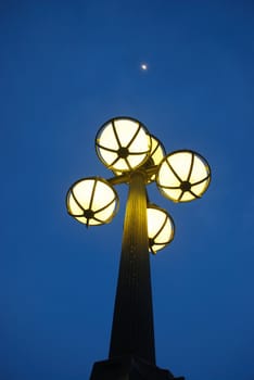 View of  antique street light against blue sky and moon. taken at singapore city in a beautiful evening