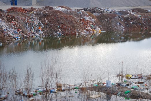 Trash floating polluting water in a pond.