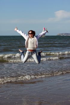 Happy jumpers girl on the beach