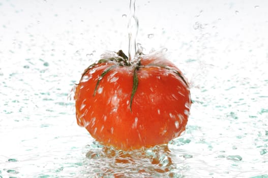 On a ripe red tomato pour water