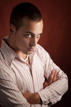 Handsome young man standing with folded arms