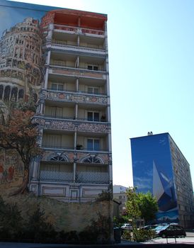 One of the many painted buildings in Lyon, in France. Indeed in Lyon there are many buildings painted like this with many different drawings. They paint this like a normal picture but on the walls of big buildings. In this one It is represented many things but we can see the tower of Pise in Italy.