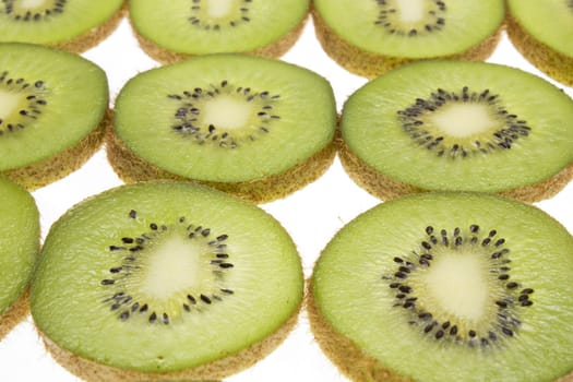 Close up of slices of kiwi fruit on white background.