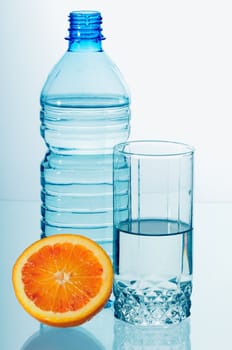 Water in a plastic bottle and a glass isolated on white background