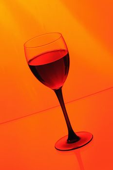 Wineglass with red wine  on orange background