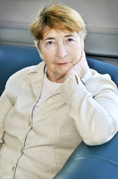 Elderly woman sitting in white linen jacket