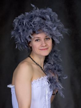 Portrait of the beautiful girl with a boa on a head