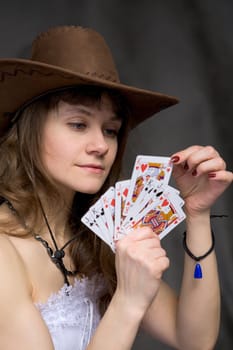 Portrait girl with a playing-cards in hand on black