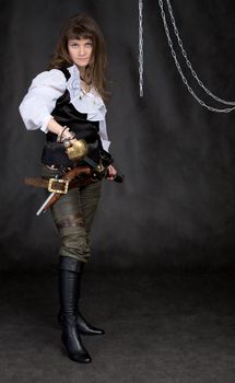 The girl - pirate with a sabre in hands on a black background