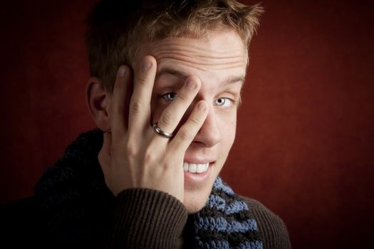 Young man covering face with his hand