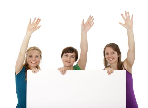 Three young women holding a blank banner, greeting and smiling.