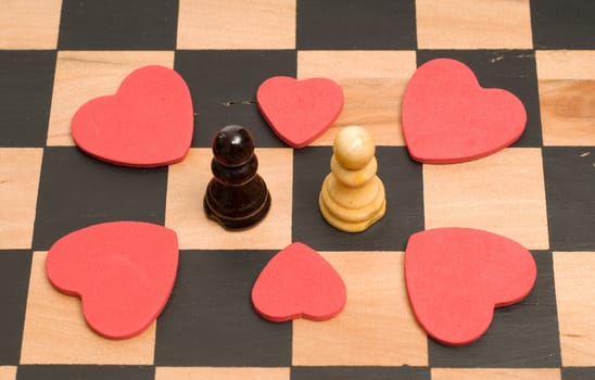 Concept image of love and romance, using chess pieces and red hearts