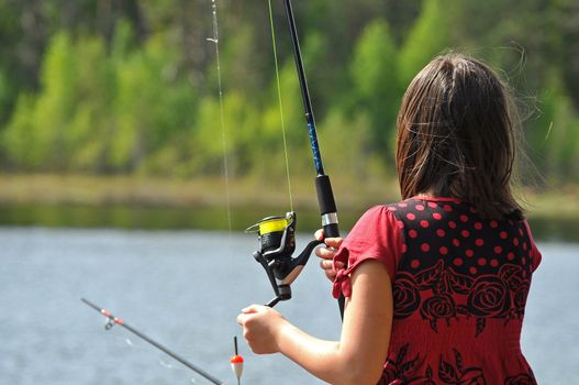 A young girl out fishing the swedish wilderness.