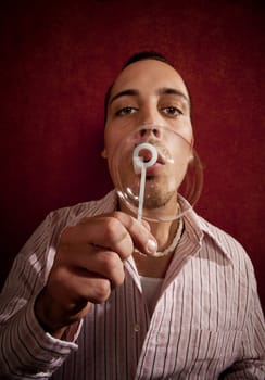 Handsome young blonde man blowing a bubble