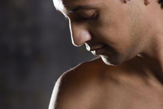 Muscle man on dull background against sharp light  