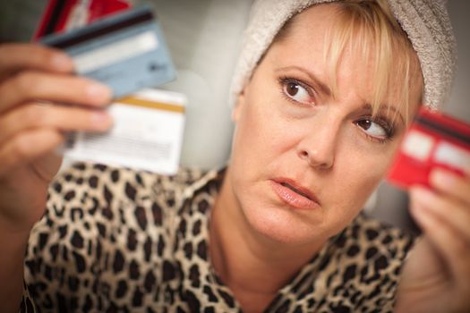 Upset Robed Woman Glaring At Her Many Credit Cards.