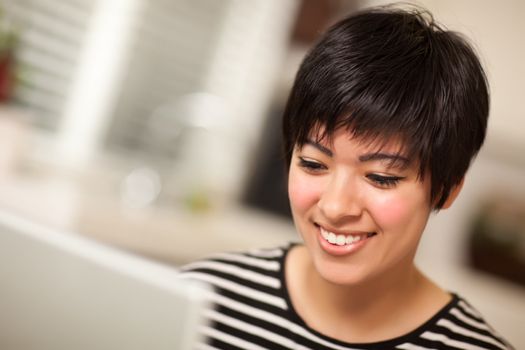 Pretty Smiling Multiethnic Woman Using Her Laptop Computer.