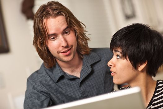 Happy Young Caucasian Man and Multiethnic Woman Using the Laptop Computer Together.