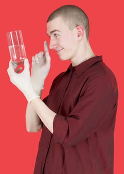 Boy hold glass of water on the red background