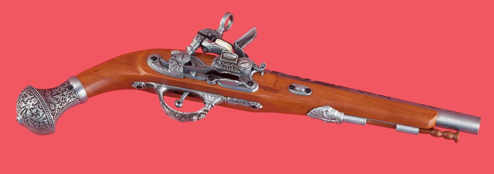 The old ancient pistol on red background