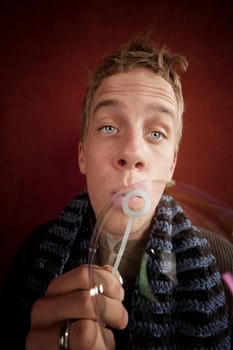Handsome young blonde man blowing a bubble