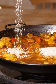 Poruing rice into a paella pan, traditional cooking