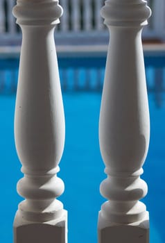 Two columns of a balustrade against the background of a pool