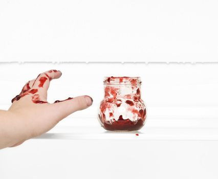 Hand trying to reach the Jam Can in a fridge