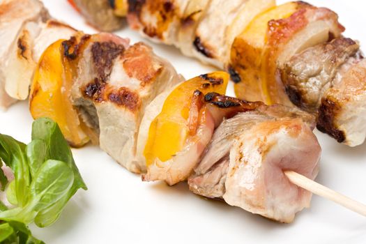 shashlik on a plate with a tomato and salad leaf