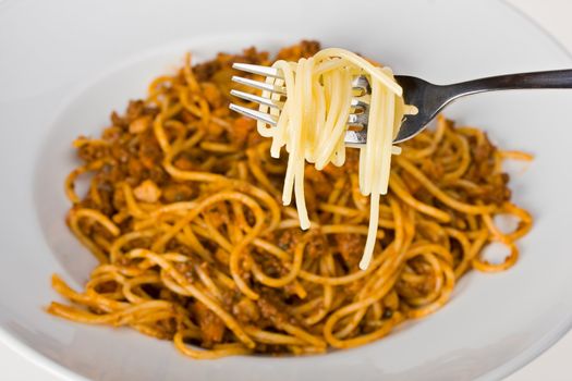 fork over a plate with spaghetti bolognaise