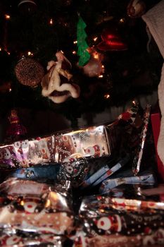 christmas tree decorations hanging from the tree with wrapped presents underneath