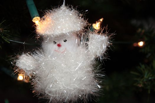 a christmas tree snowman decoration hanging from the tree