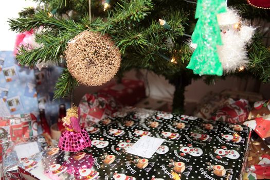 christmas tree decorations hanging from the tree with wrapped presents underneath