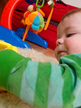 Cute little baby boy playing with colourful toys