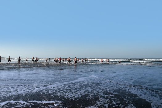 people some dressed in santa hats doing a christmas swim for charity