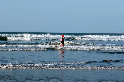 woman dressed in santa hat doing a christmas swim for charity